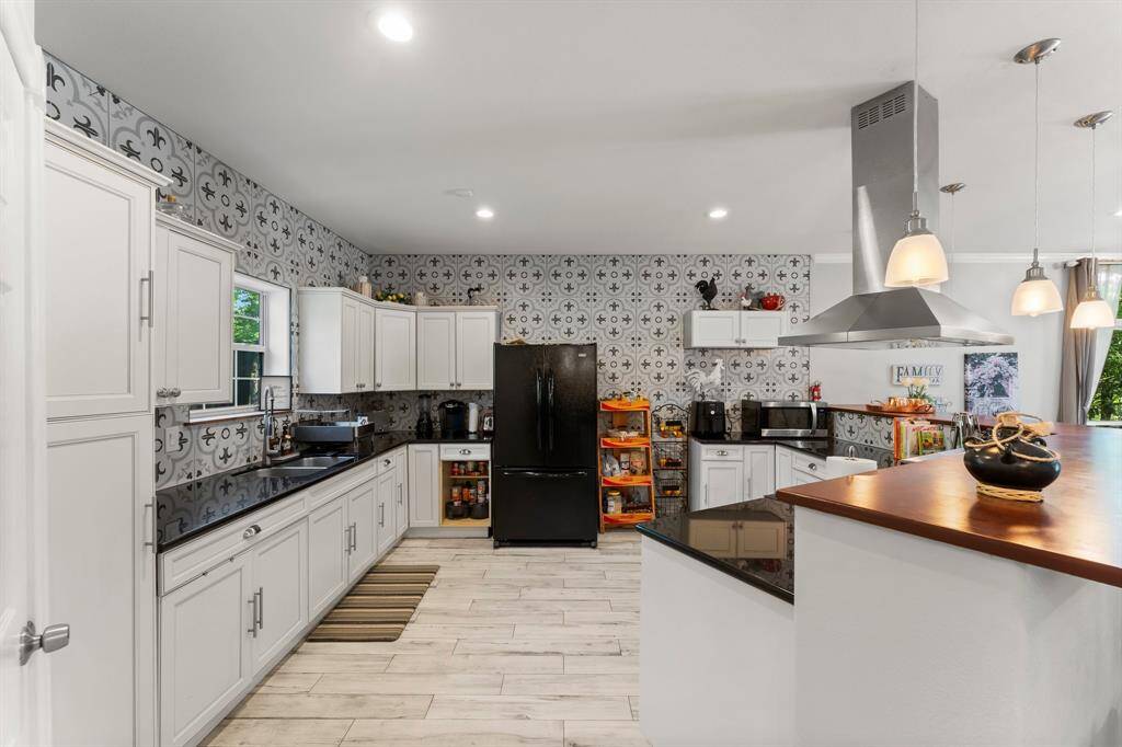 Enjoy cooking in this bright and functional kitchen featuring white cabinets, contrasting countertops, and modern appliances. The thoughtful layout provides plenty of workspace, making it a joy to prepare meals and entertain.