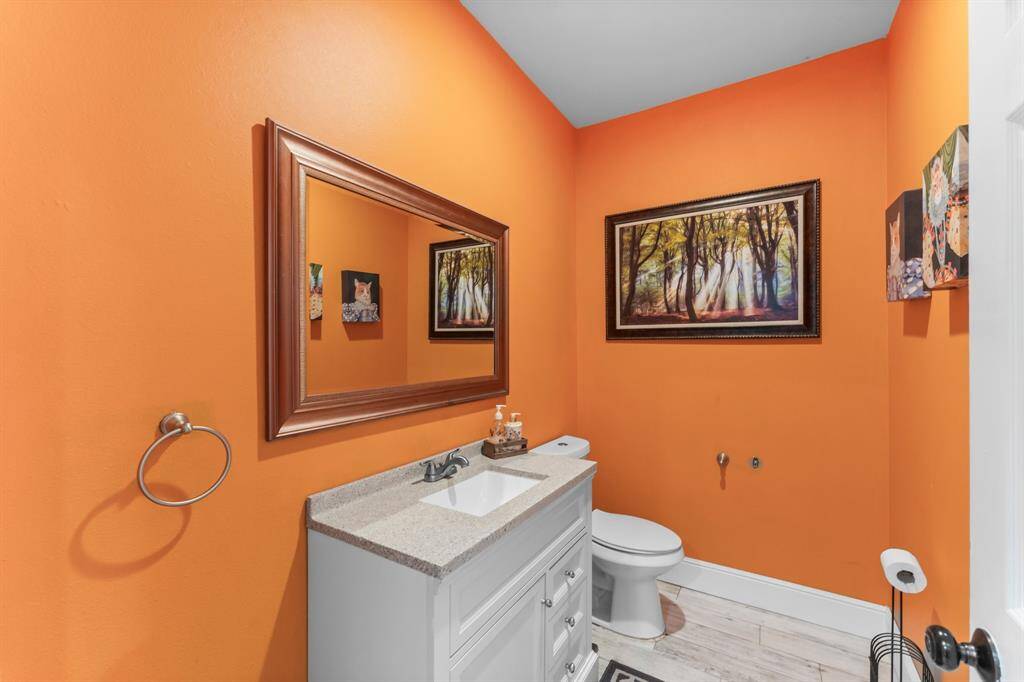 Bright and functional bathroom with a stylish vanity, modern fixtures, and a vibrant wall color.