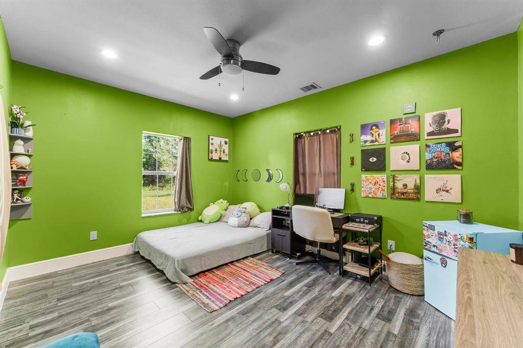 This comfortable bedroom offers a bright and versatile space, perfect for relaxation or as a home office. Featuring ample natural light and stylish flooring, it's ready for personalization.