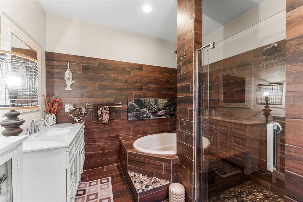 This bathroom offers the best of both worlds with a separate soaking tub for unwinding and a spacious walk-in shower. The stylish tile work and modern fixtures enhance the sense of comfort and luxury.