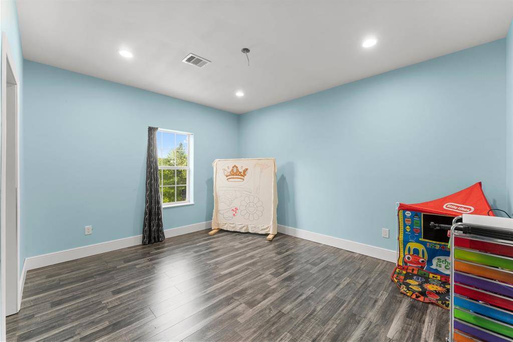 Bright and airy bedroom offers a flexible space ready for its new occupant's personal touch. With ample natural light and stylish flooring, it's a blank canvas awaiting your design ideas.