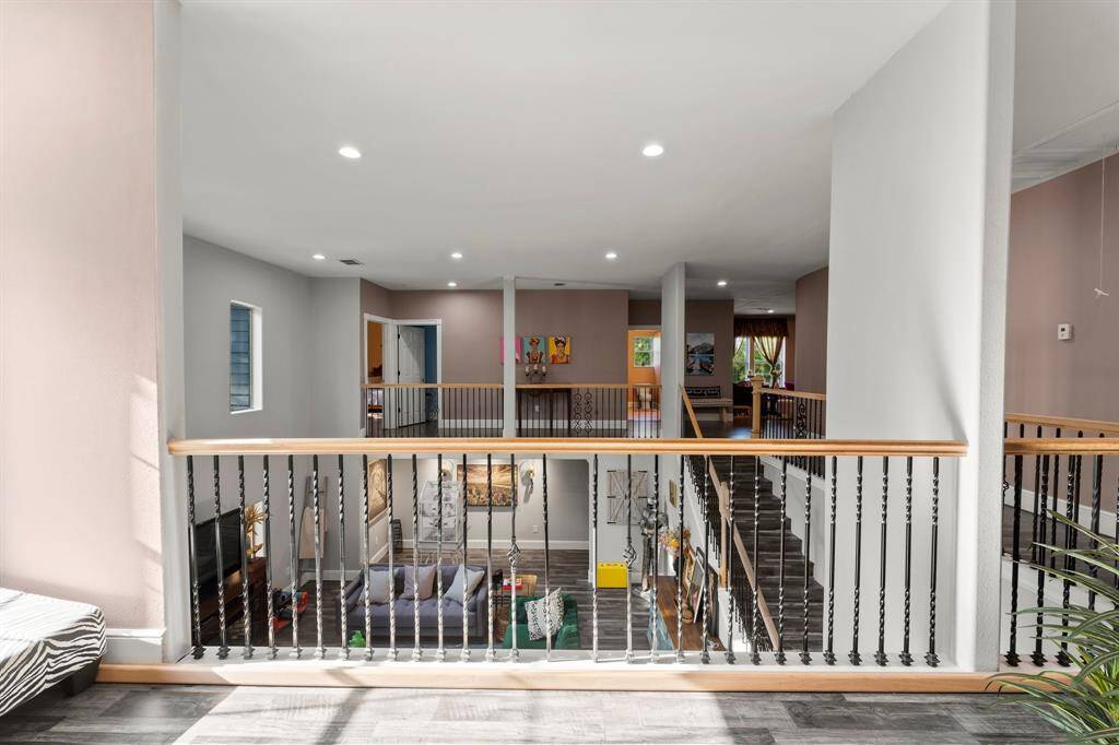 This vantage point from the upper level highlights the home's architectural design and the seamless flow between floors. Enjoy the open view into the living spaces below, creating a bright and interconnected feel.
