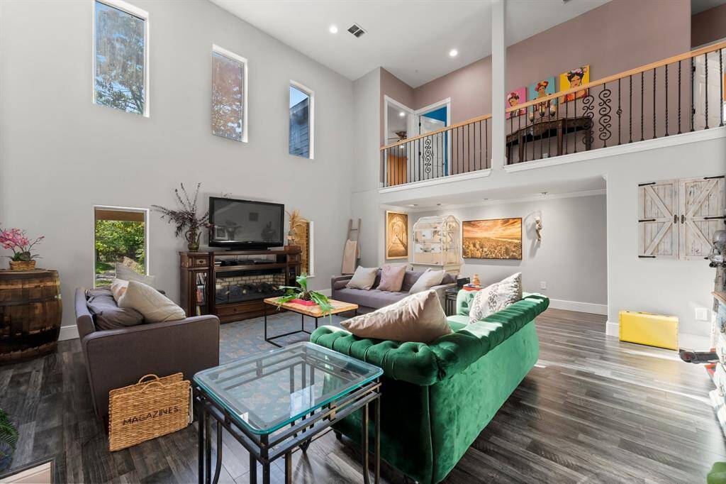 Experience the dramatic impact of soaring ceilings and an open design in this impressive living room. The abundance of natural light from the upper windows enhances the spacious feel, creating a bright and airy atmosphere perfect for both relaxation and entertaining.