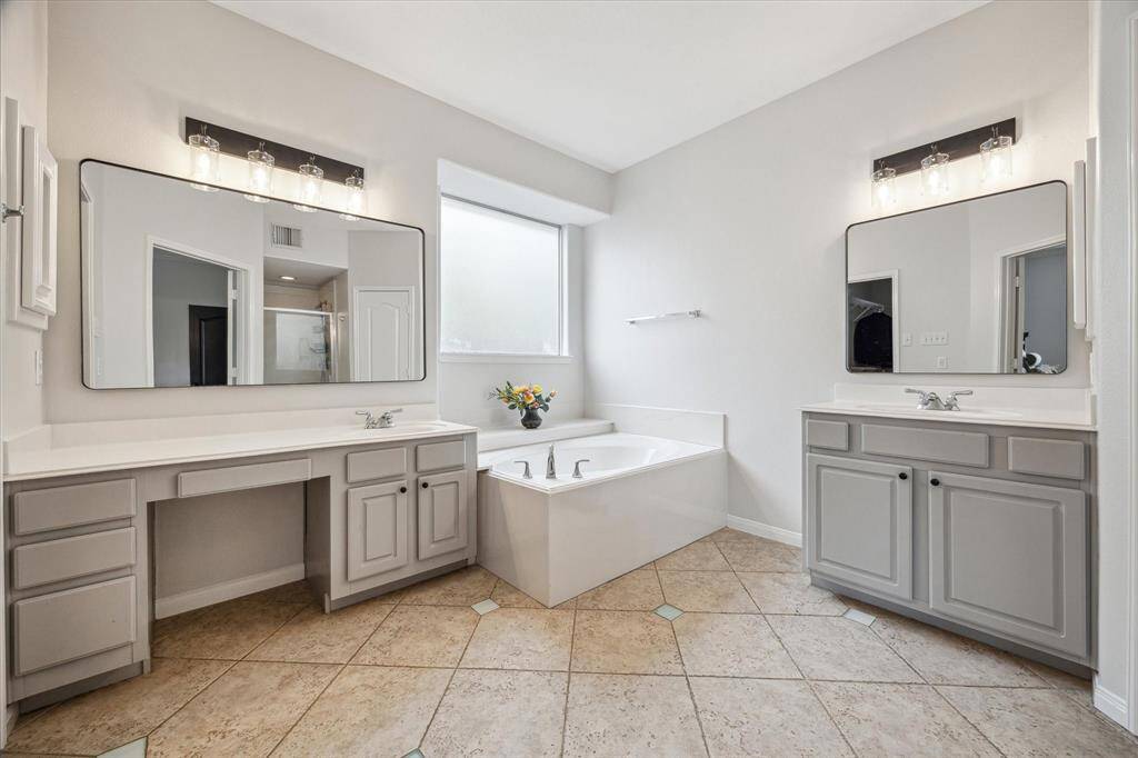 Large primary bathroom with dual vanities and separate soaking tub!