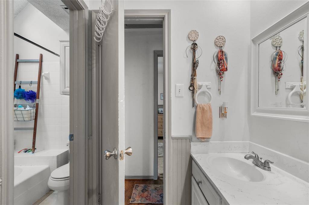 This bathroom offers the ease of double sinks and a well-lit shower, with abundant overhead lighting that creates a bright, open atmosphere. Its thoughtful layout—next to the master and directly across from the spare room—makes sharing the space a breeze for everyone.