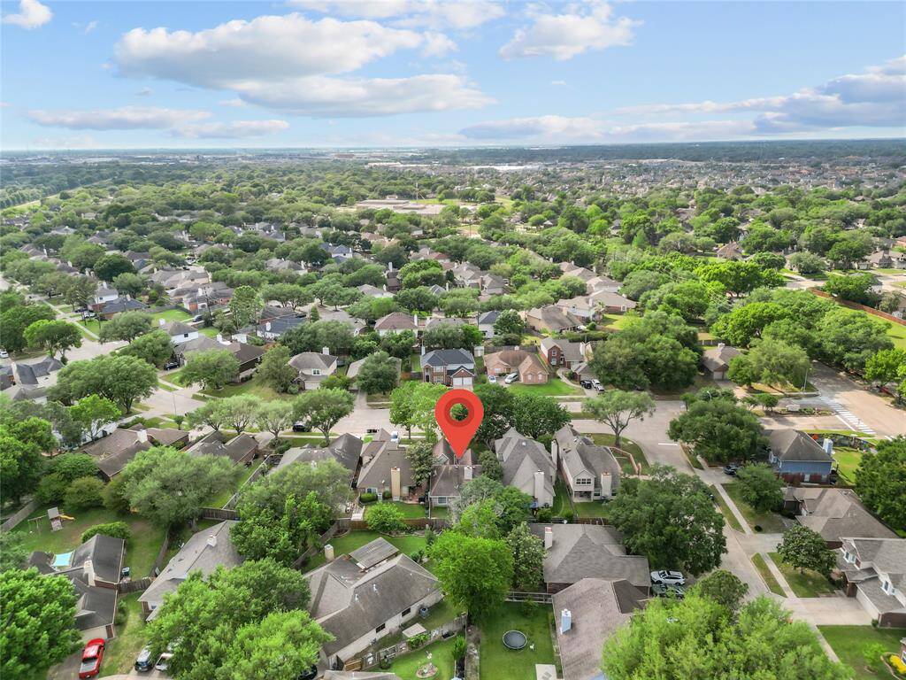 A cozy, welcoming home with a classic front porch and neatly manicured lawn, featuring an attached garage with a smooth, paved driveway. The warm exterior is complemented by tasteful landscaping, creating a perfect blend of comfort and charm.
