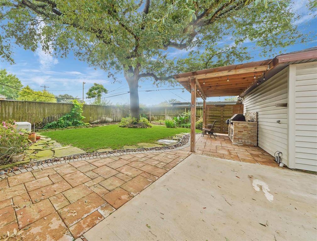 Step out into the backyard, and notice the expanded patio, the outdoor kitchen, the expanded covered patio and all that green space and landscaping.