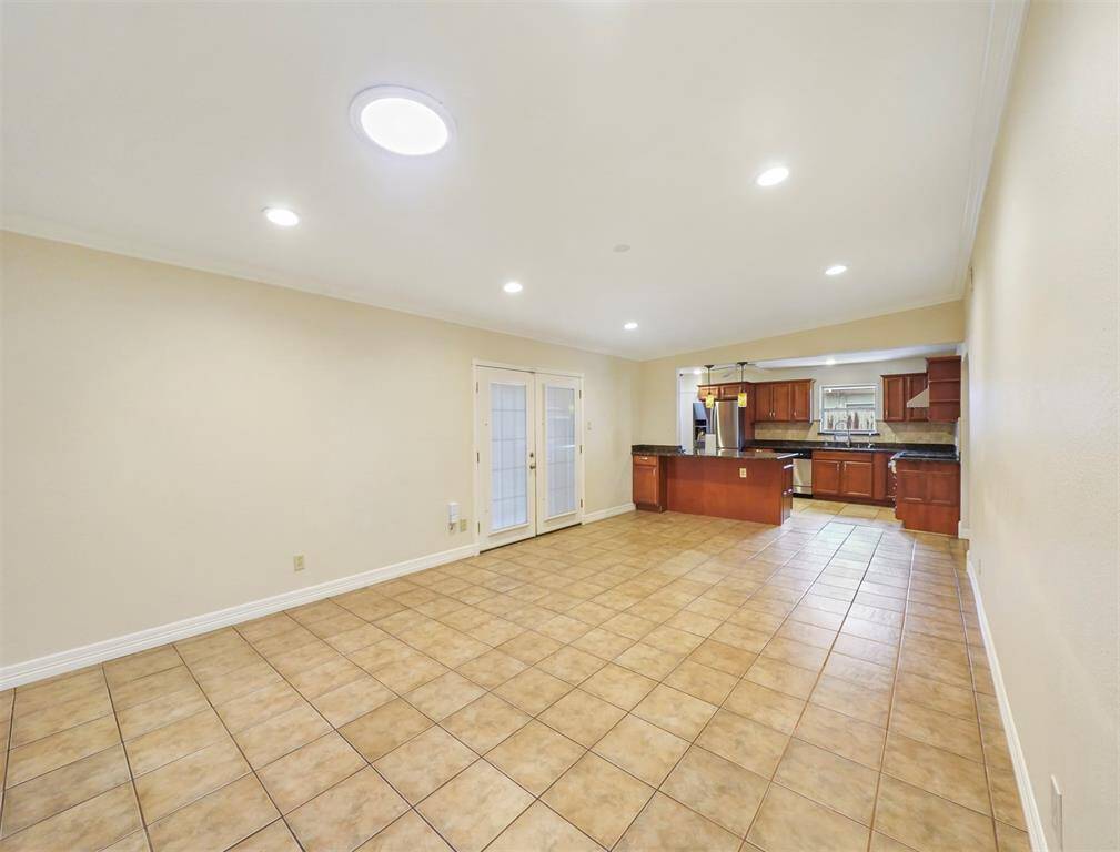 Step through the archway and notice the large dining and kitchen space, with access to the back patio.