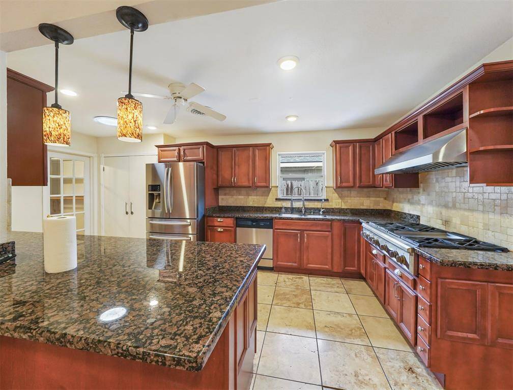 The kitchen is fully equipped. Custom cabinetry, professional stainless steel appliances, a 6 burner cooktop and flat top, plus granite counters make this a chef's dream kitchen.