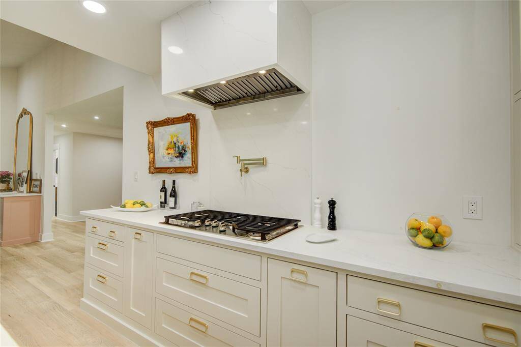 Notice the quality of appliances. The vent hood has also been wrapped in the matching quartz countertop! But where is the oven, you ask?...just wait!