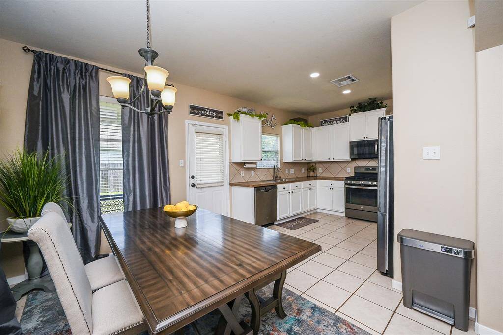 The eat-in kitchen is the heart of the home, boasting a stylish tile backsplash, ample cabinetry, and the perfect spot for a cozy breakfast nook.