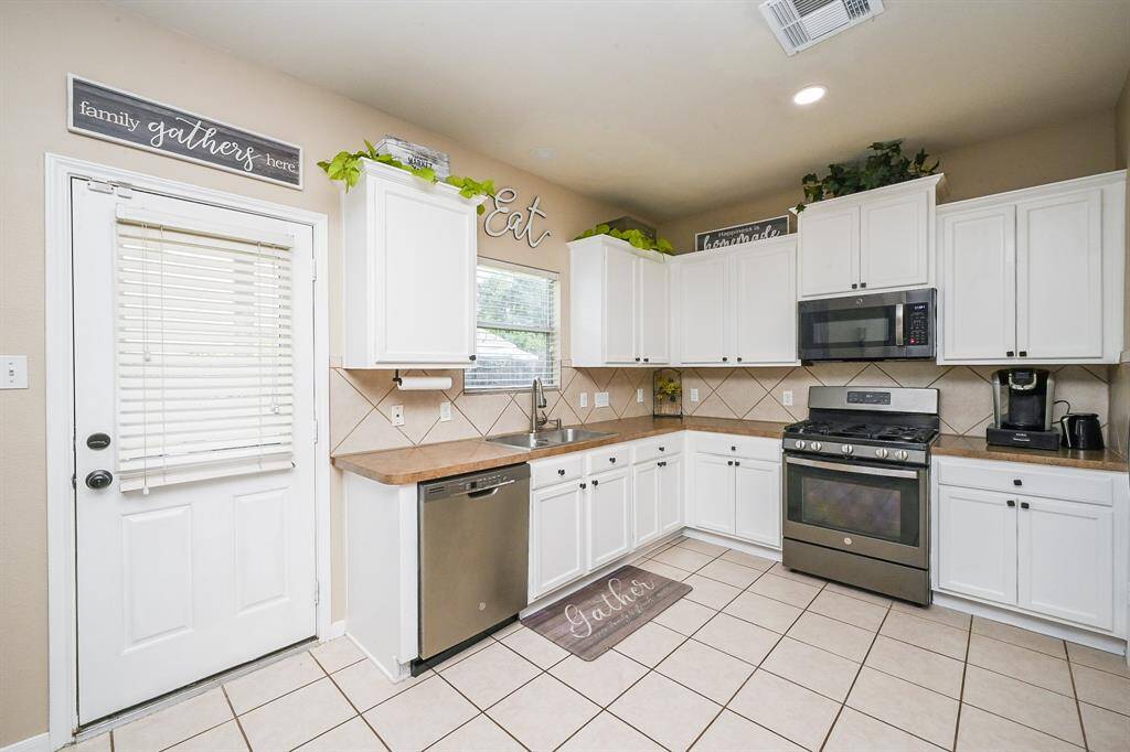 Sleek stainless steel appliances pair beautifully with crisp white cabinetry, creating a clean, contemporary look that’s as functional as it is stylish.