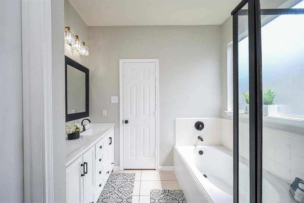 The en-suite bathroom offers a spa-like retreat with a garden tub and separate glass-enclosed shower.