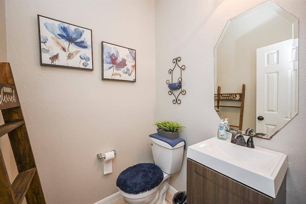 This half bath is thoughtfully designed for guests' convenience. Its compact layout ensures functionality while maintaining a sleek, clean look, making it a perfect space for quick visits or freshening up.
