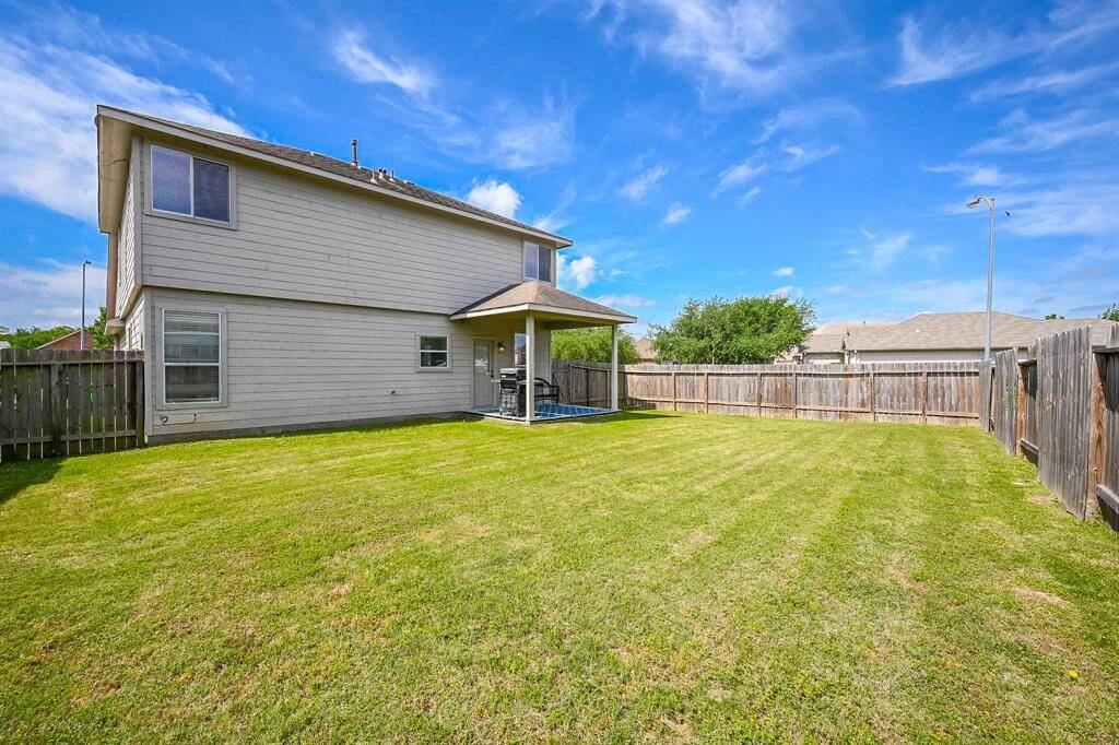This large yard offers plenty of space for kids to play, run, and explore, with lush grass and room for creative outdoor activities.