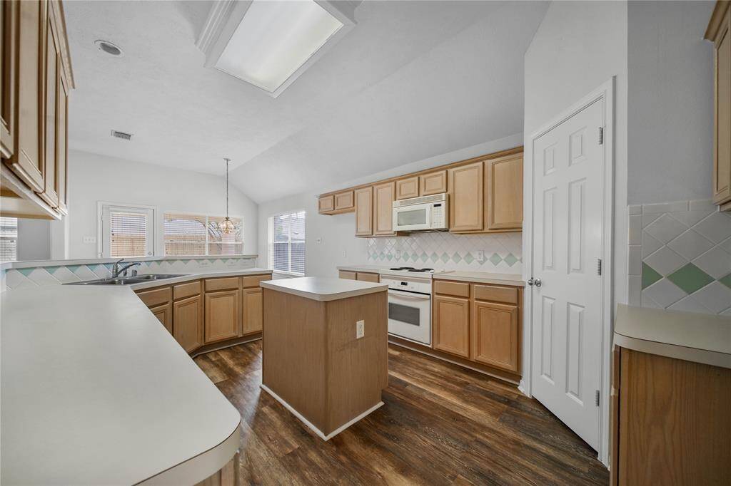Island kitchen has lots of storage and counter space.  New microwave just installed!