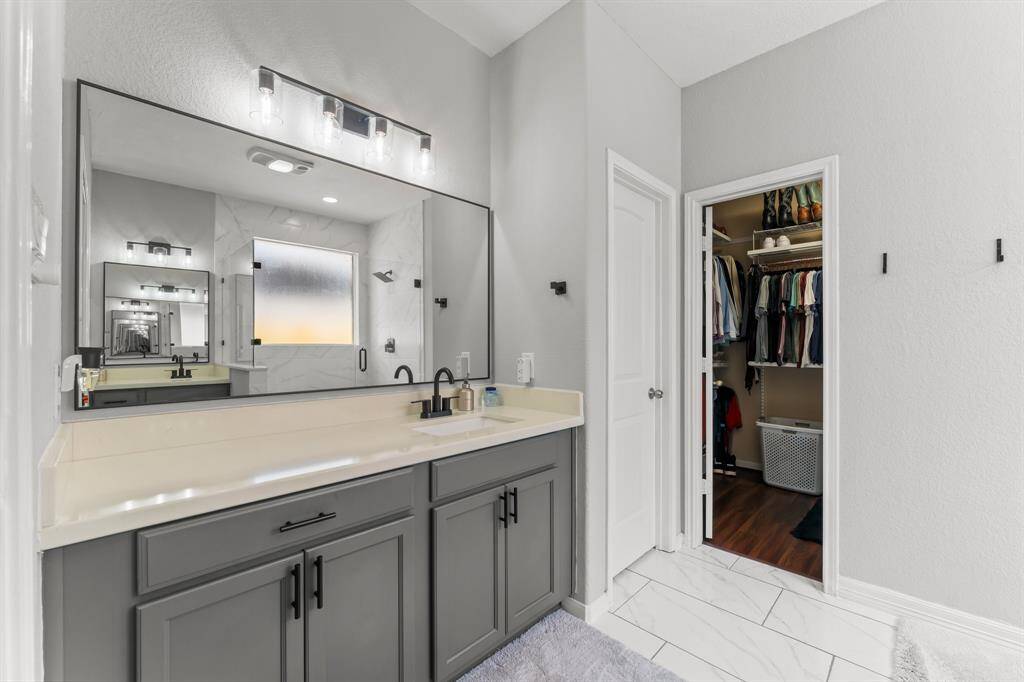 View of the other vanity with custom mirror.  Water closet and large walk-in closet to the right.