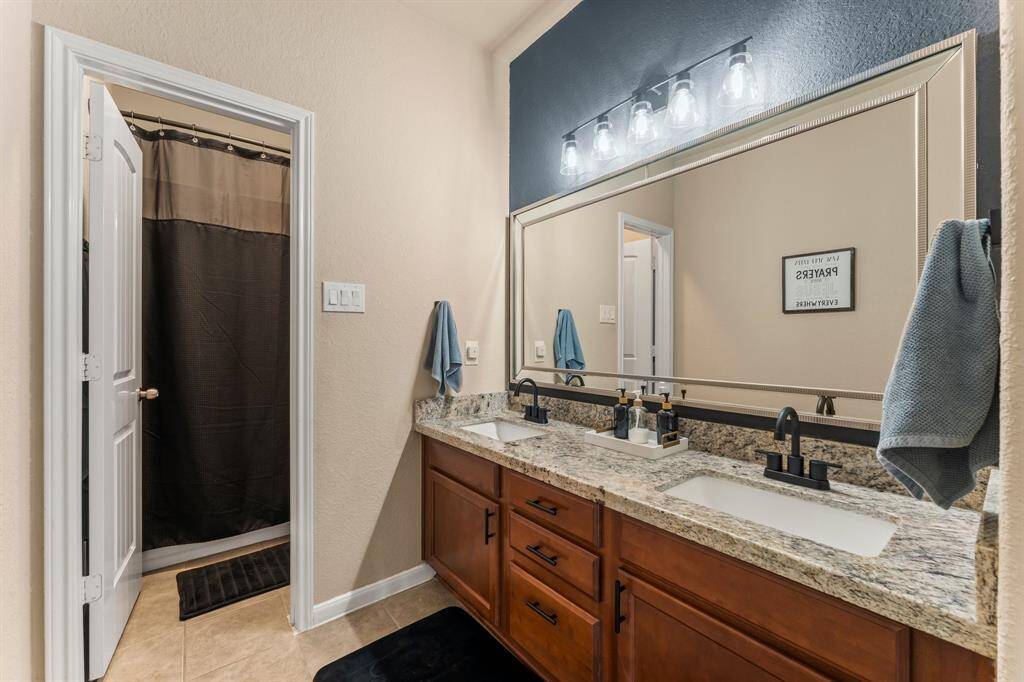 Secondary bathroom features new countertop, sinks, faucets, and custom mirror.