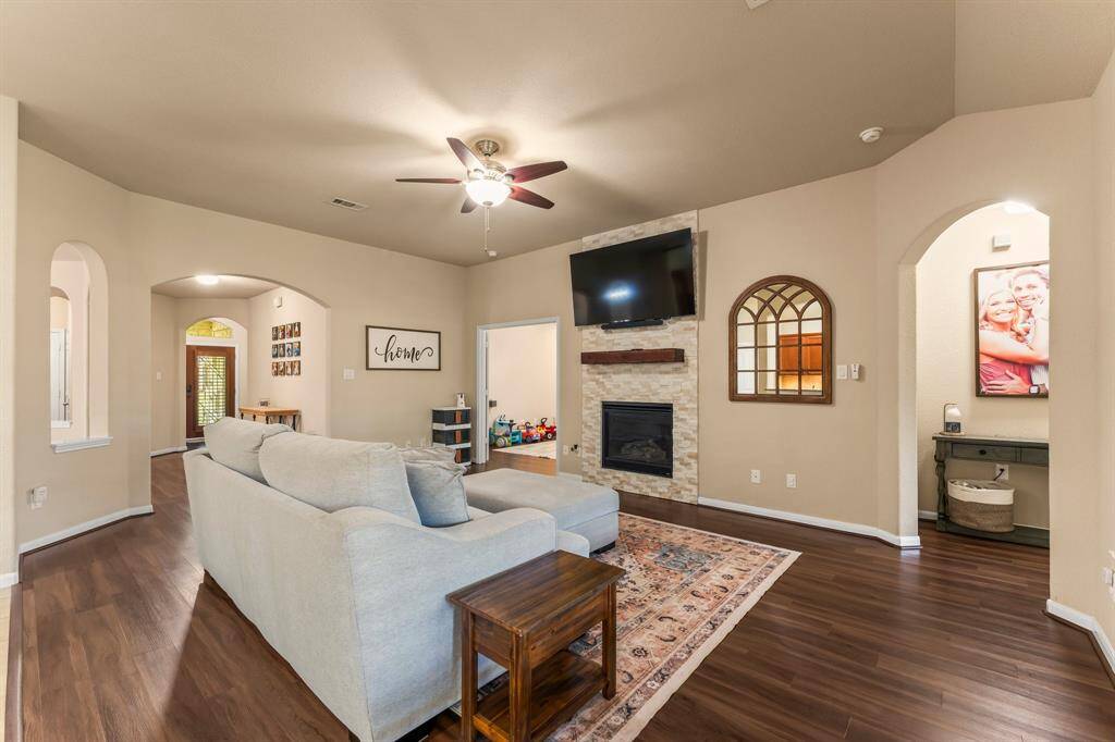 Fireplace updated with stone and a mantle.  Primary suite located on the right.  The fourth bedroom that may also be used as an office is located on the left.