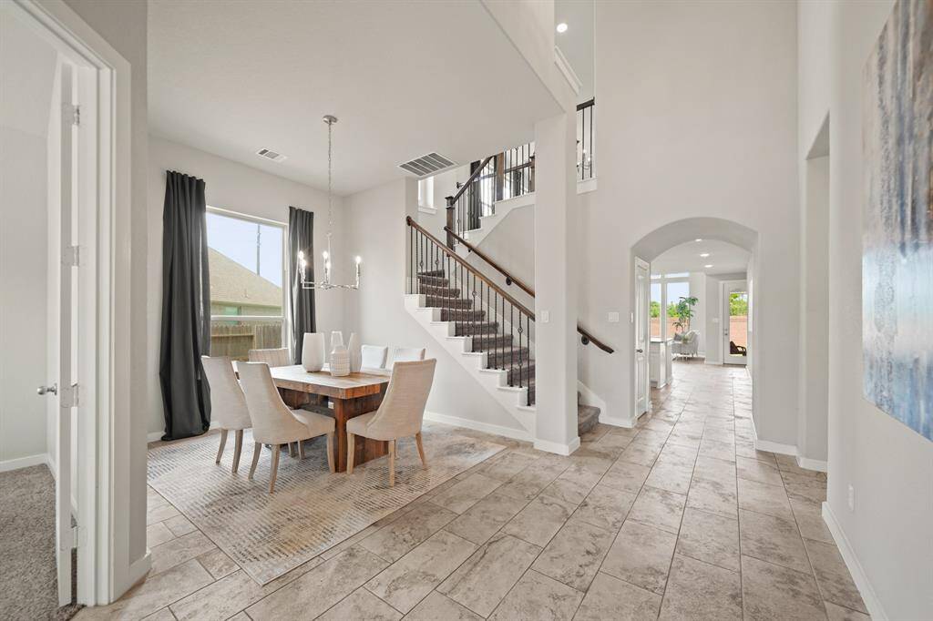 A Glimpse of What’s to Come.This inviting view captures the graceful flow from the entryway to the formal dining, with the staircase ahead and natural light pouring in from the living room beyond. Each space effortlessly connects, offering a preview of the home’s thoughtful design.