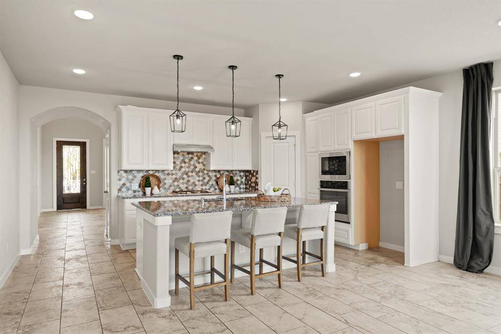 Effortless Connection.From the oversized living room, enjoy a full view into the bright, inviting kitchen—designed to keep conversations flowing and daily life seamless. Clean sightlines and intentional design draw your eye toward the entry, giving the entire space a sense of calm and cohesion.