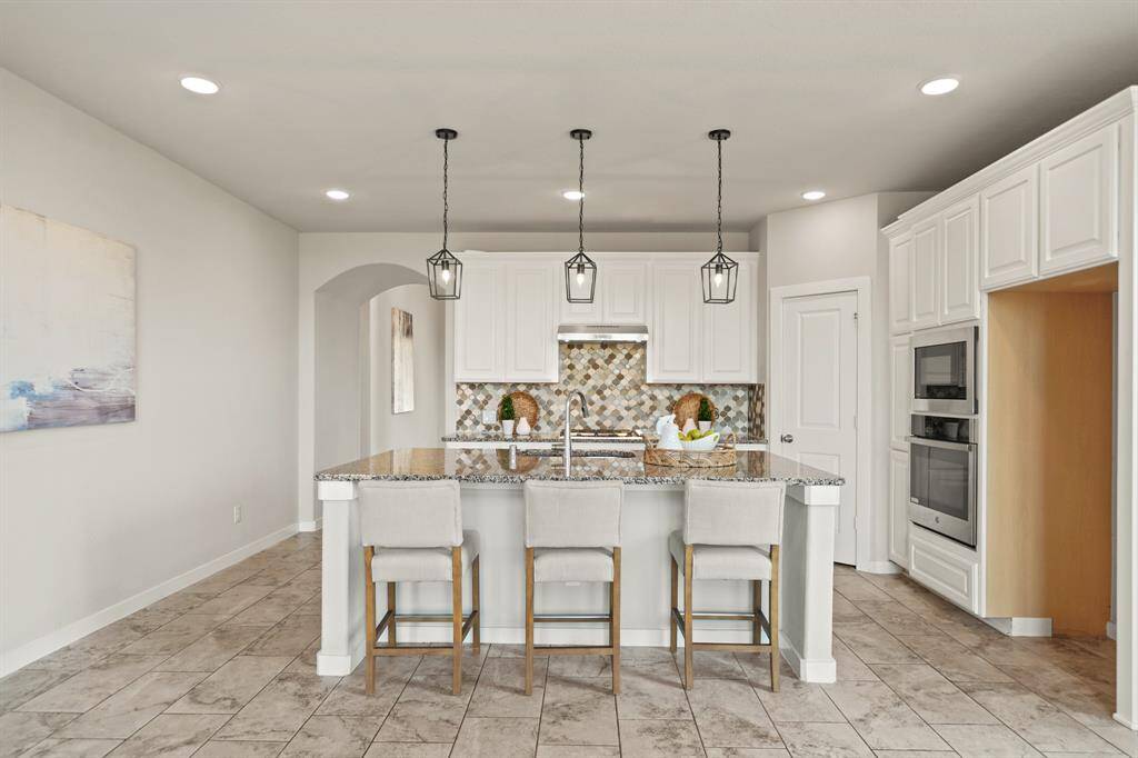 Gather, Savor, Enjoy.This spacious island offers room for bar stools and meaningful moments. Surrounded by elegant cabinetry and rich flooring, it’s a space where everyday meals turn into lasting memories—designed for connection and comfort.