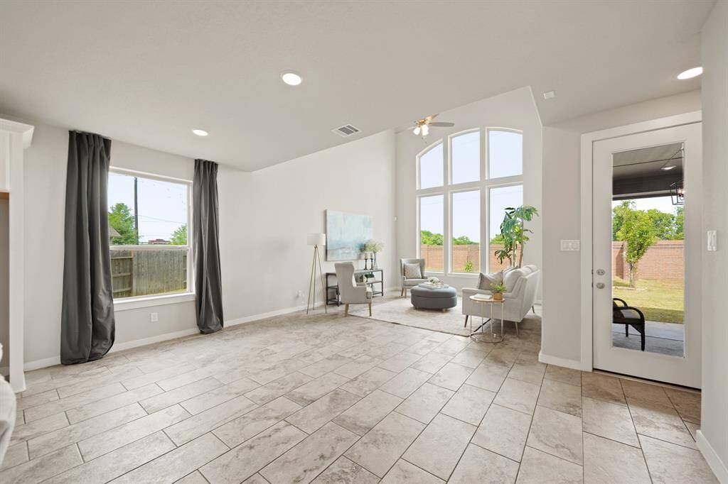 Indoor-Outdoor Living at Its Best.This expansive living room features beautiful windows and a glass back door that effortlessly connects to the covered patio and backyard. Flooded with light, this space invites relaxation and entertaining, offering the perfect backdrop for every occasion.