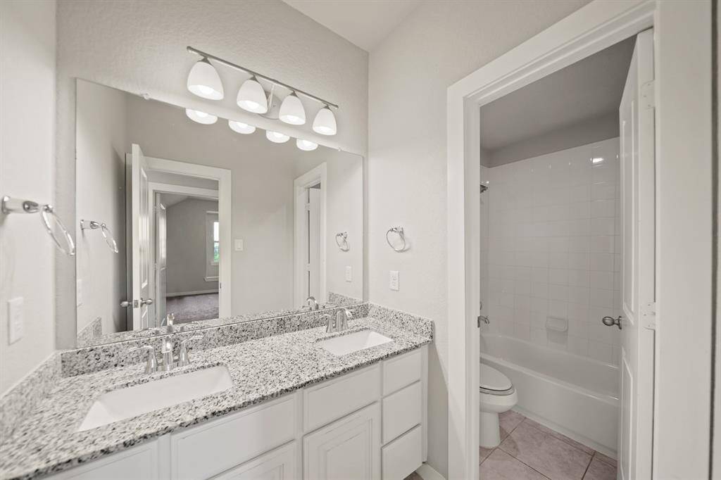 Private En-Suite Retreat.This spacious en-suite bedroom offers a serene atmosphere with an open door revealing a glimpse of the full bathroom inside. Enjoy privacy and comfort in this thoughtfully designed personal space.