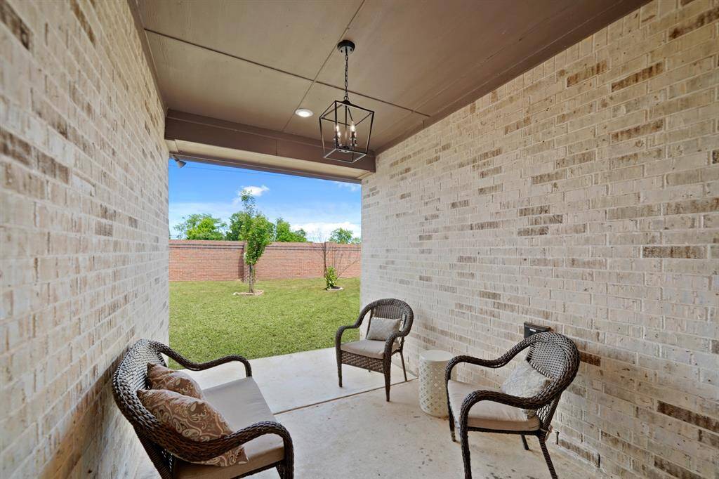 Charming Covered Patio.From the spacious yard, take in the view of the covered patio and back door—a seamless connection between indoor and outdoor living. With plenty of room to relax or entertain, this space invites comfort and style.