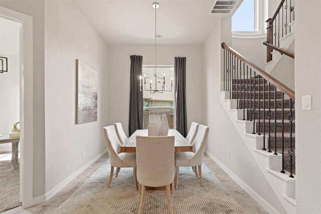Elegance in Every Meal.The dining room, graced by large windows and a stunning hanging light fixture, offers an inviting atmosphere for both intimate dinners and grand gatherings. With plenty of space to savor every moment, this room is designed for cherished memories.
