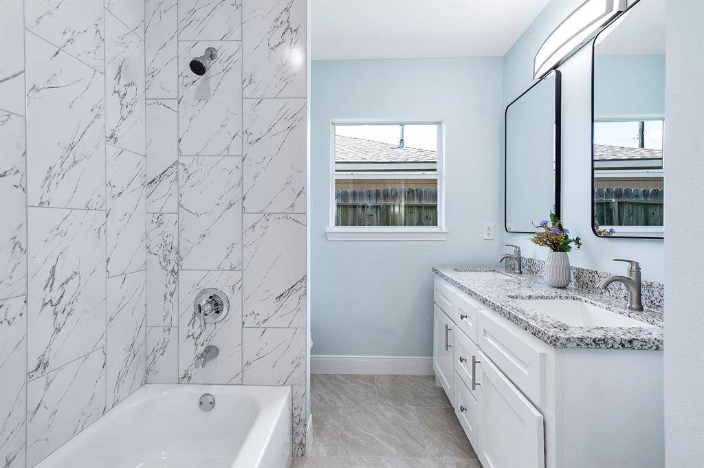 Secondary bathroom complete with luxury tile tub surround and double sinks.