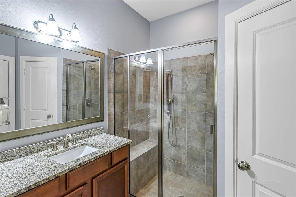 The guest suite bath features oversized shower and single sink vanity.