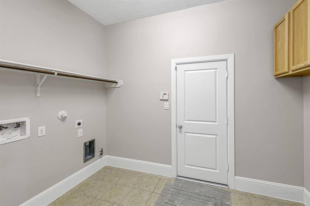 Utility room offers closed storage and room for overflow fridge and freezer appliances.