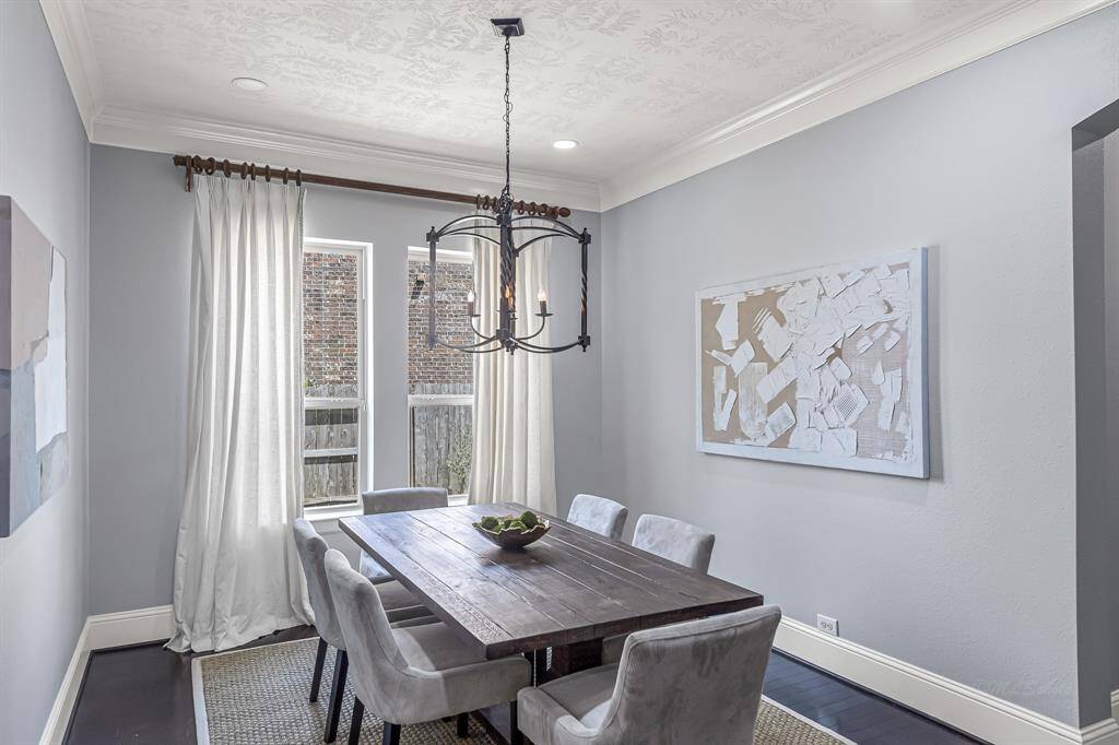 The formal dining room is beautifully appointed with soft window panels, crown molding, and recessed lighting. Also note the substantial baseboard molding for a truly custom finish.