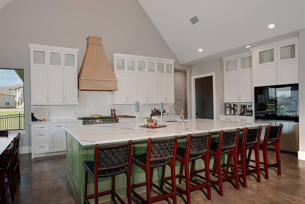 The kitchen island is large enough to sit six people while preparing meals on the professional grade gas stove.