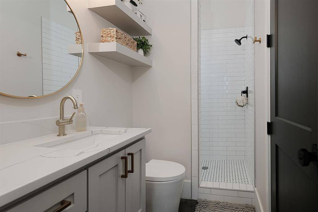 Another angle of the second full bathroom with extended quartz counter and walk-in shower.