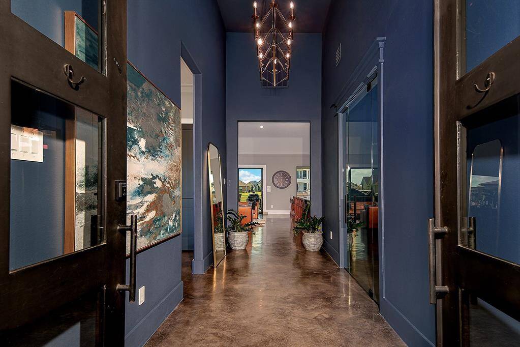 Double wrought iron doors lead you to the formal entry with chandelier and soaring ceiling.