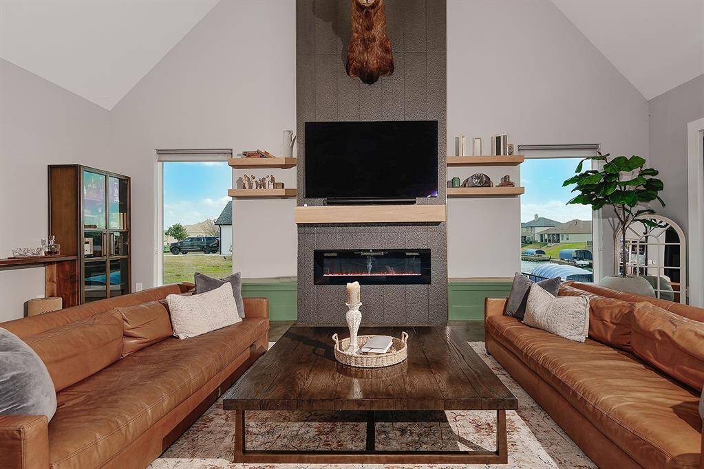 Gather around the electric fireplace lined in bronze tile, white oak mantle/floating shelves and storage benches.