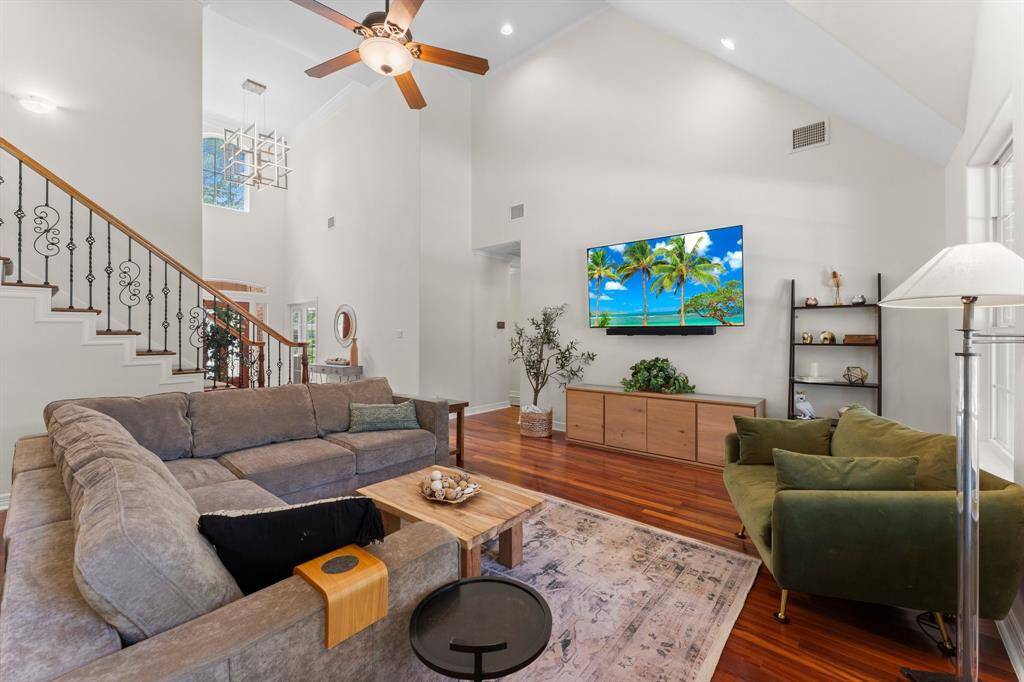 What a fantastic living room! Hallway to the left of the tv leads you to the primary suite, a half bathroom and around to the office's second entrance.