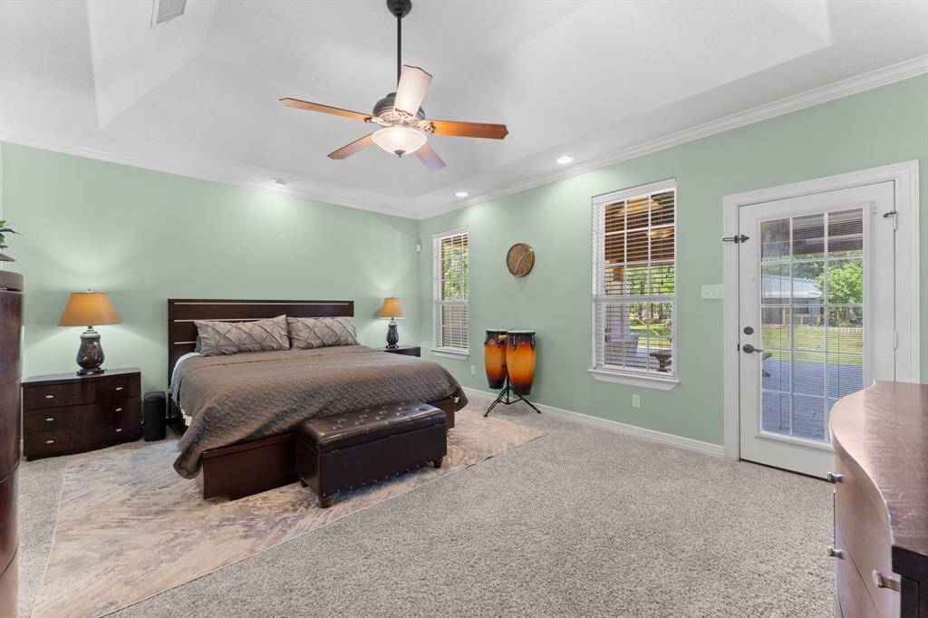 The fantastic primary suite with door leading to the covered patio.