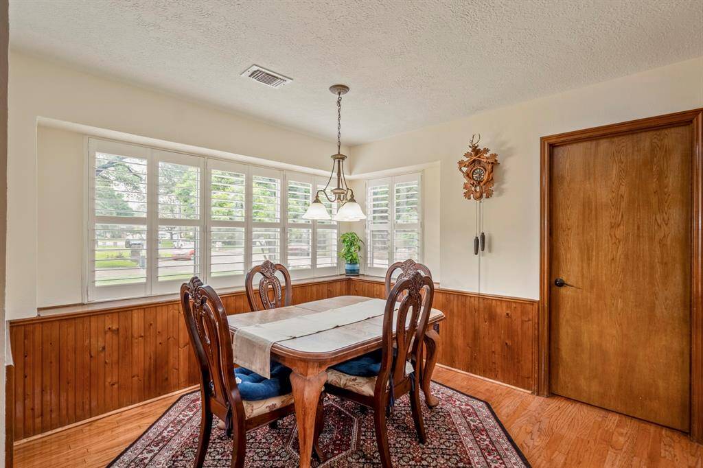 Breakfast Room features wainscotting and windows overlooking the front yard with plantation shutters