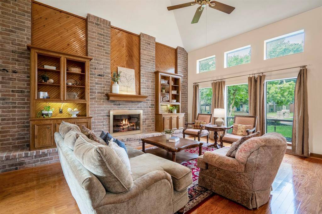 Family Room features brick accents, built-ins, a fireplace and views out of the picture windows.