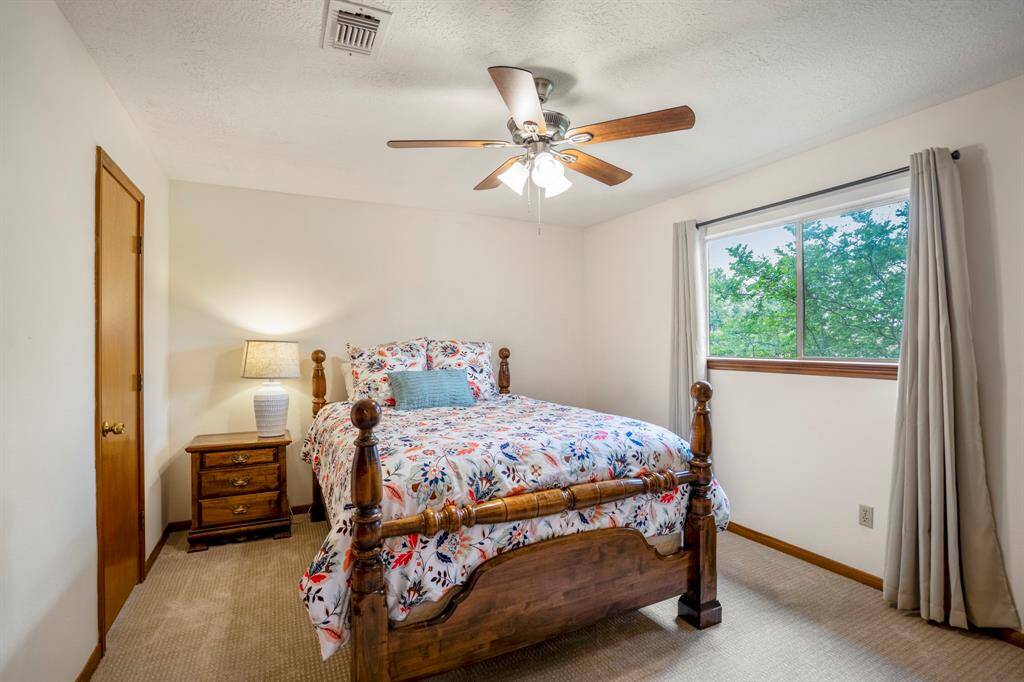 Secondary upstairs Bedroom with carpet and a ceiling fan this bedroom had an ensuite bath.