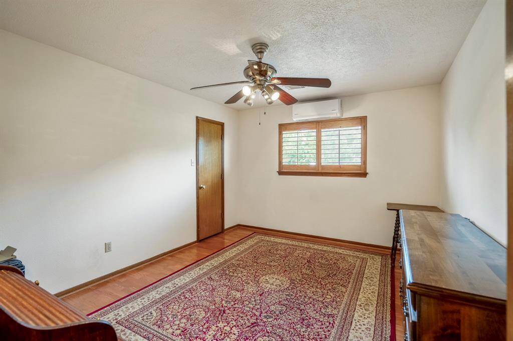 Secondary upstairs Bedroom with wood floors, a walk in closet, and a ceiling fan