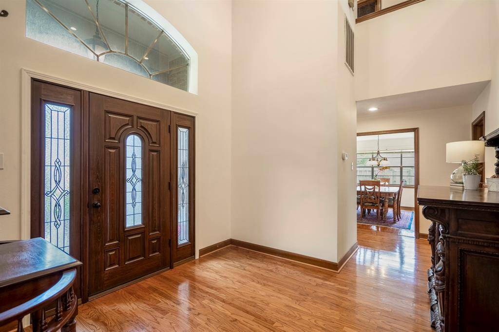 Foyer features high ceilings and wood floors.