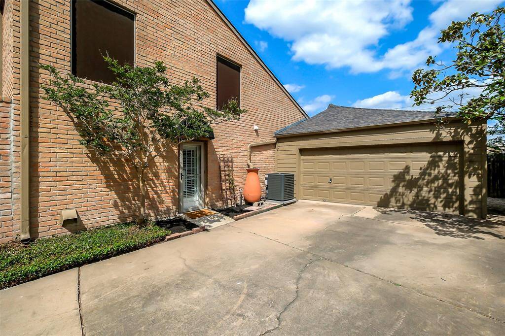 View of the driveway leading to the 2 car garage and side entry to the home.