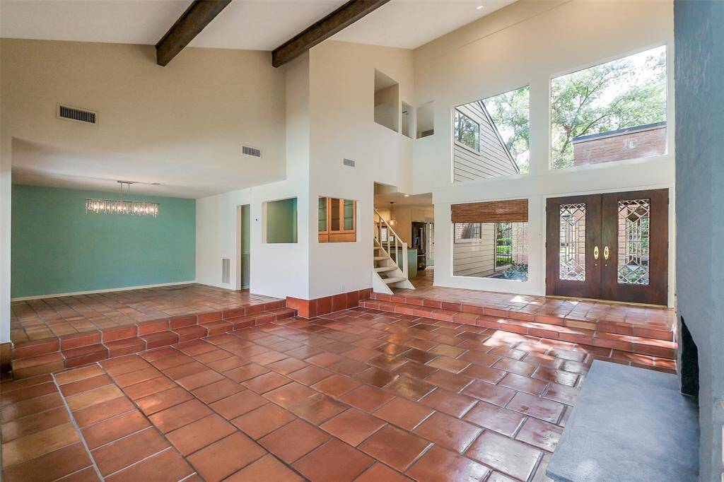 Ample natural light & high ceilings. This view includes the bar, formal dining room & living area. Recently completed designer finishes, including updating, painting, fixtures & lighting.