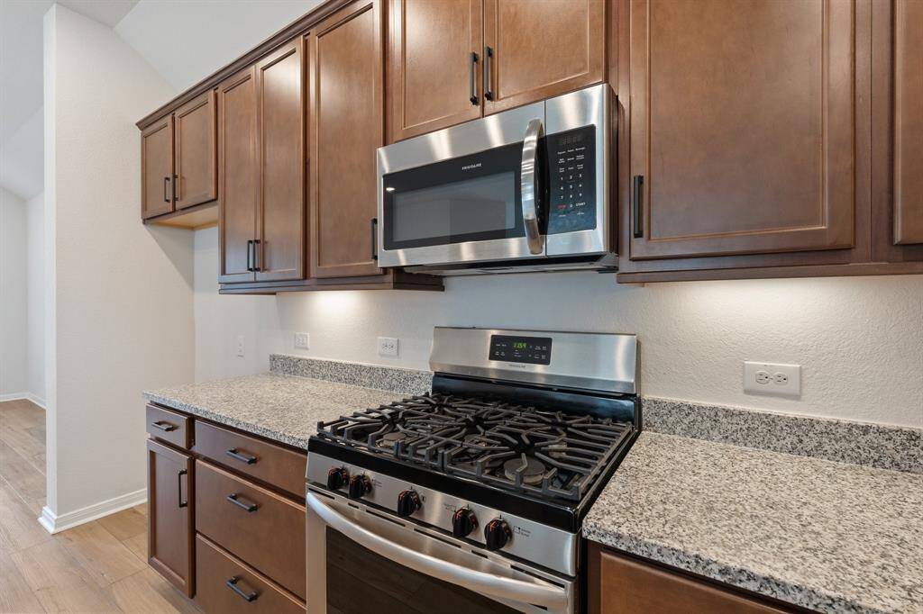 Gas range, microwave, beautiful dark wood cabinets