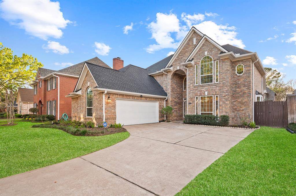 Welcome Home! A brick elevation is surrounded by lush landscape and mature trees offering great curb appeal.