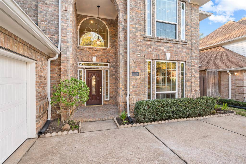 An arched walkway leads you to a quaint covered front porch!